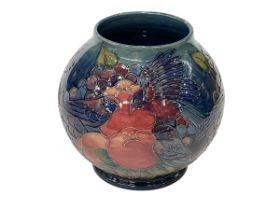 Moorcroft Pottery Finches and Fruit vase of globe form, tubelined with birds pecking fruit, 17cm.