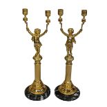Pair of gilt metal candle holders modelled as cherubs with torch raised in both hands upon a reeded