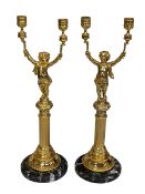 Pair of gilt metal candle holders modelled as cherubs with torch raised in both hands upon a reeded
