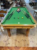Slate bed snooker table on turned leg base, 77cm by 121cm by 227cm, together with cues,