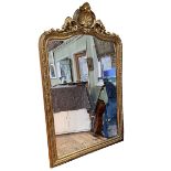 Large gilt framed arched top bevelled wall mirror with shell, swag and floral crest, 230cm by 140cm.