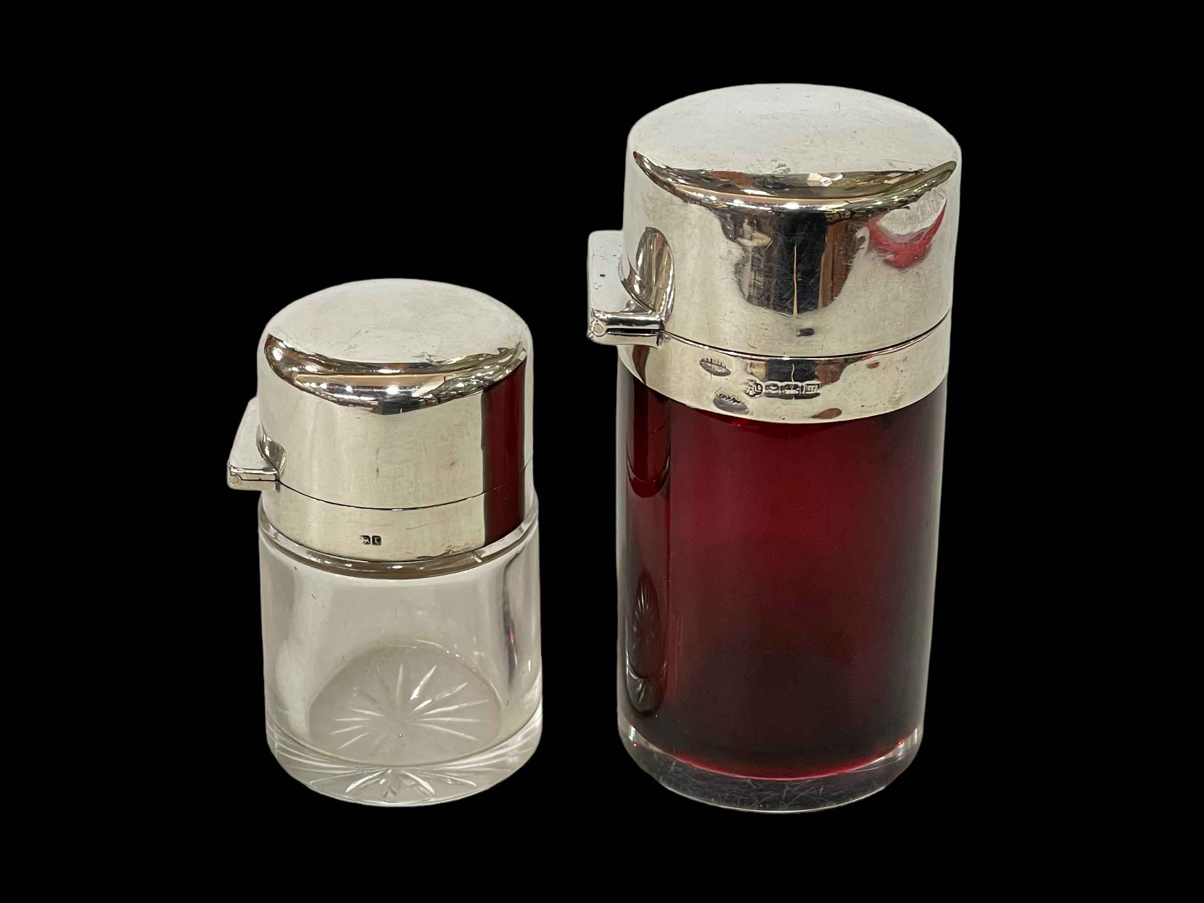 Two silver topped toilet bottles, ruby glass Birmingham 1911, 10.5cm and other Birmingham 1891.