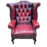 Ox blood buttoned leather and studded wing armchair.