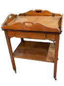 Mahogany butlers tray with folding sides on two tier stand with central drawer,