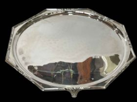 Large silver octagonal tray on scroll feet, London 1914, 44cm across.