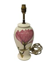 Moorcroft Pottery table lamp decorated with magnolia on cream ground.