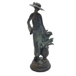 Bronze figure of an elegant lady next to flowering plant, 36cm.