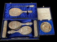 Boxed silver dressing table set embossed with cherubs, and silver replica armada dish (2).