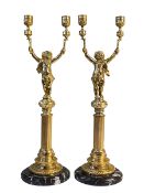 Pair of gilt metal candle holders modelled as cherubs with torch raised in both hands upon a reeded