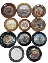 Collection of ten Pratt Ware pot lids in wooden surrounds and R Wagner plaque.