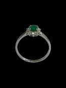Emerald and diamond cluster ring set in 18 carat white gold, size O.