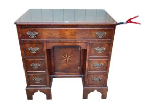 Neat crossbanded walnut kneehole desk having frieze drawer above central inset inlaid cupboard door