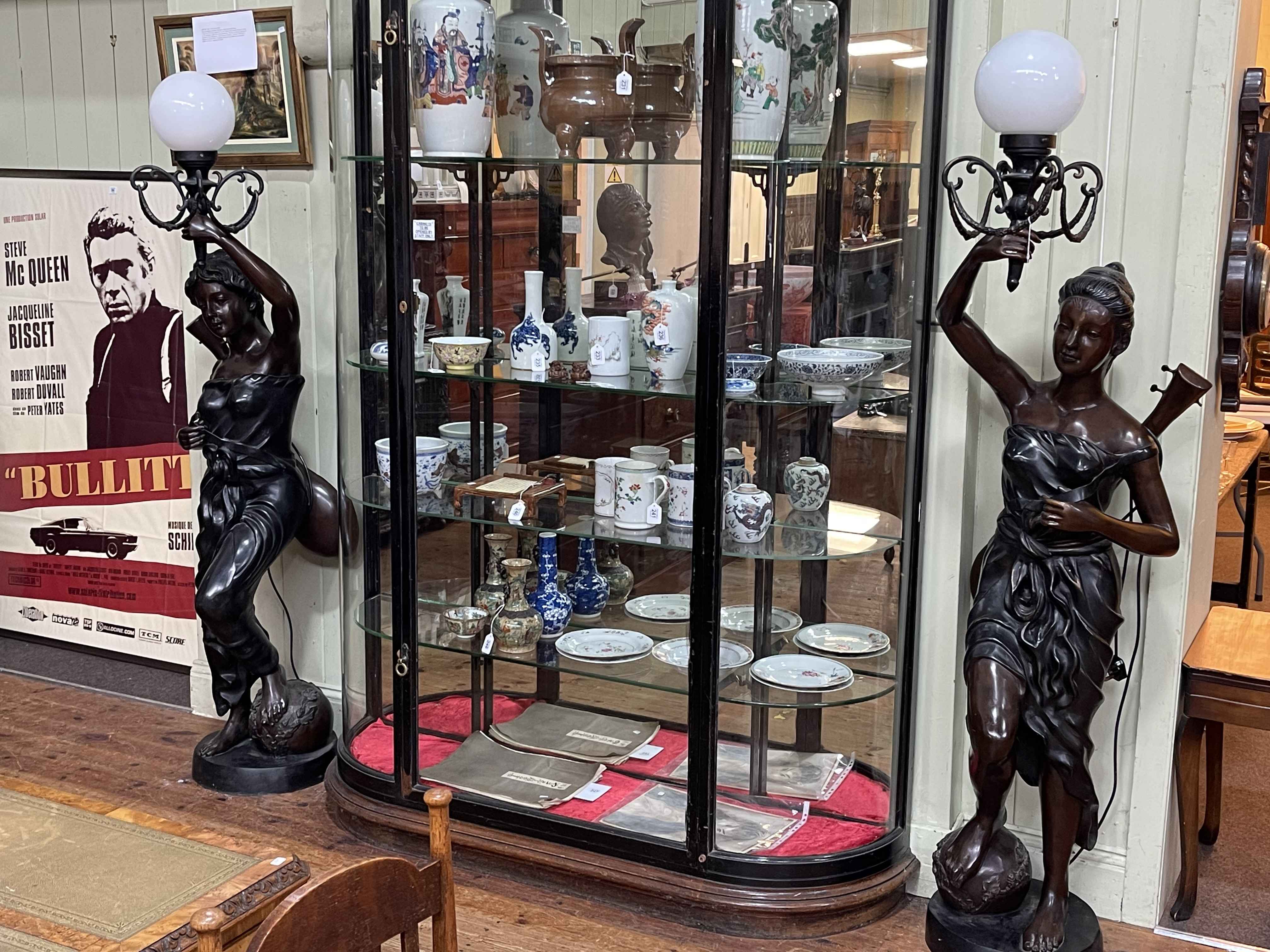 Pair of large bronzed figural floor lamps modelled as lady musicians holding a lamp aloft, 187cm.