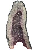 Large amethyst geode cut in half revealing naturally faceted amethysts, approximately 23kg,