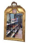 Rectangular gilt framed wall mirror with floral garland crest and circular panel, 126cm by 74cm.