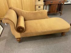 Early 20th Century scroll end chaise longue on oak turned legs.