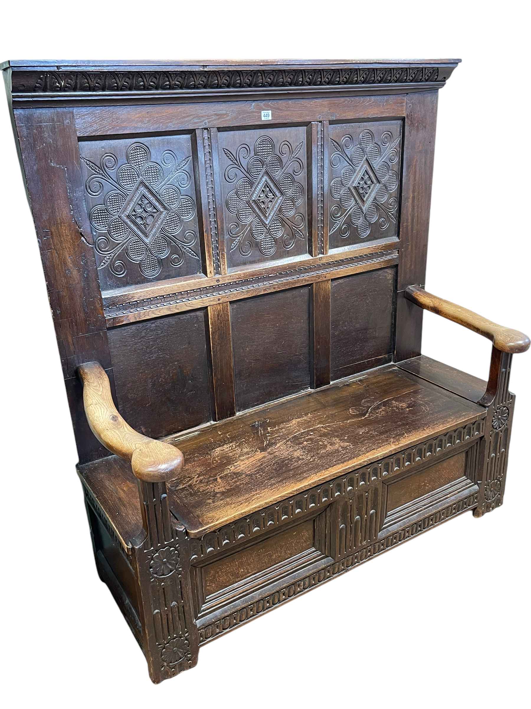 Antique carved oak high back box settle, 145cm by 137cm by 55cm.