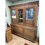 Antique oak press having central glazed panel door flanked by two mirror and fielded panel doors