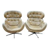 Pair retro peanut brown buttoned leather swivel egg chairs.