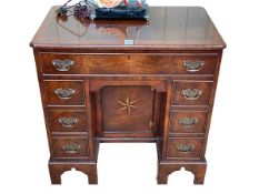 Neat crossbanded walnut kneehole desk having frieze drawer above central inset inlaid cupboard door