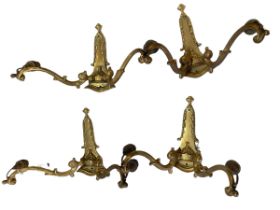 Four ornate brass Art Deco style wall lights.