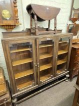 Early 20th Century oak glazed three door bookcase and oak drop leaf low table on turned legs.