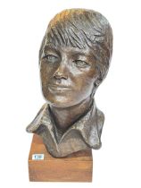 Ornate cast metal young boy bust on wooden base, 46cm high.