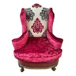Multi fabric and leather wing back armchair on ball and claw legs.