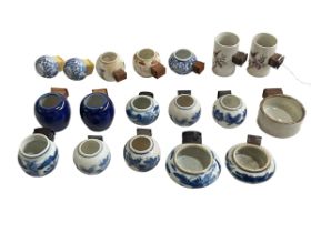 Collection of eighteen Chinese porcelain bird feeders, antique and later.