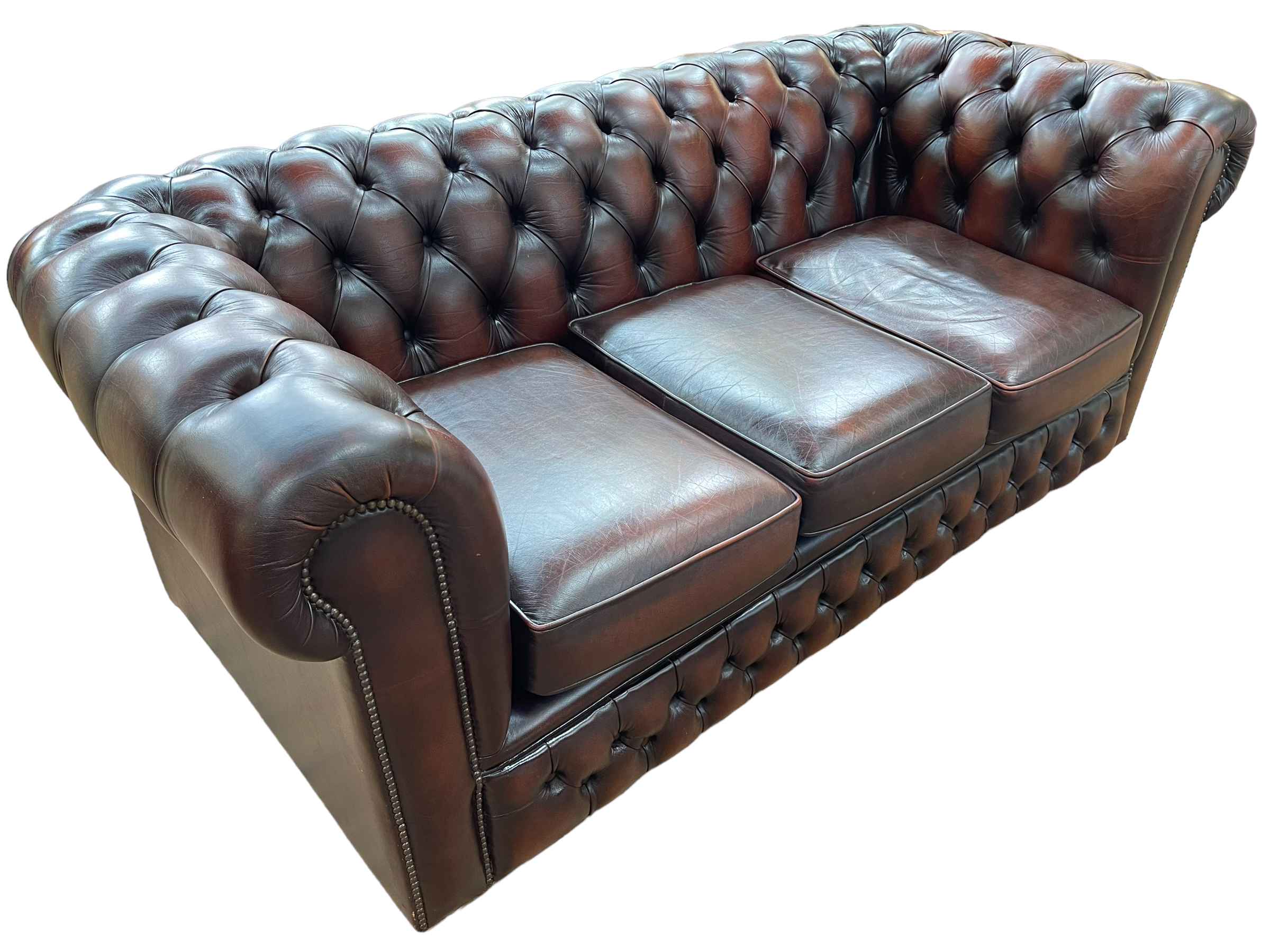 Brown deep buttoned and studded leather three seater Chesterfield settee, 74cm by 193cm by 89cm.