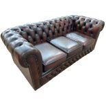 Brown deep buttoned and studded leather three seater Chesterfield settee, 74cm by 193cm by 89cm.