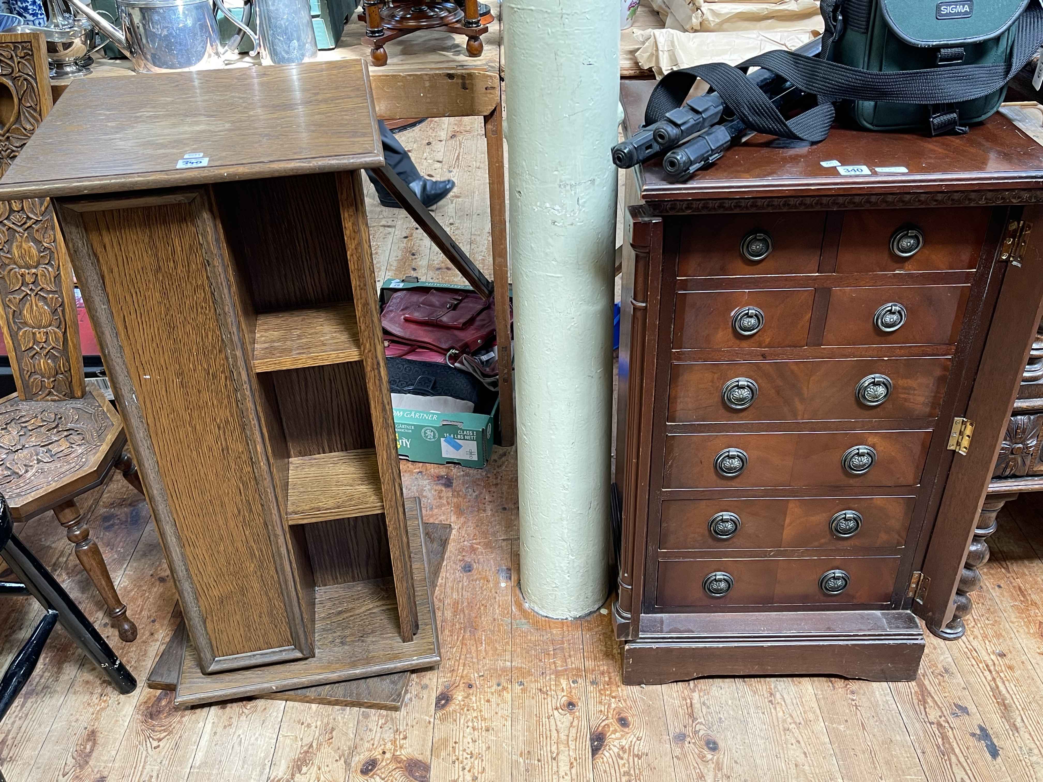 Mahogany eight drawer Wellington chest and oak finish revolving bookcase/CD rack.