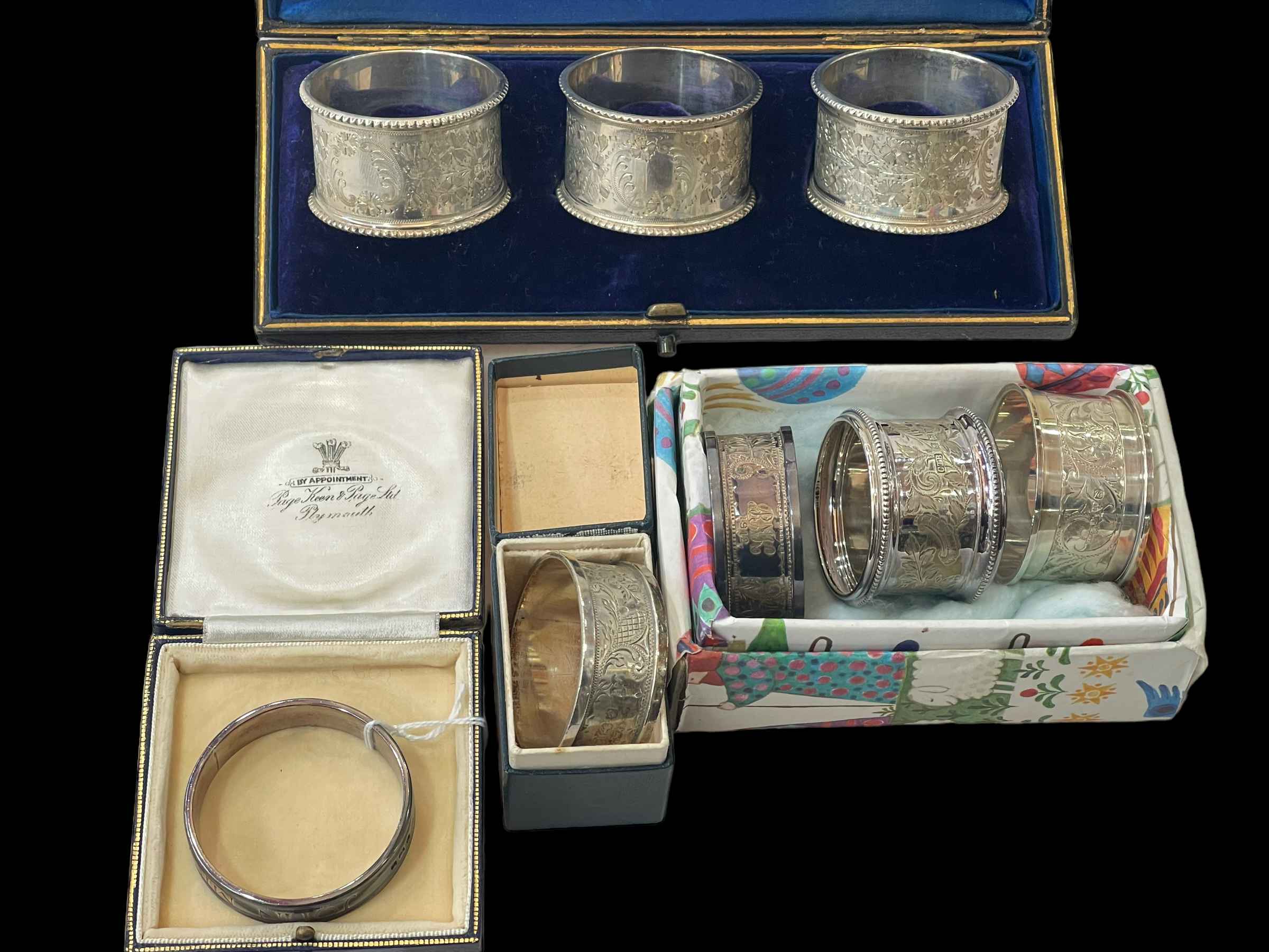 Cased set of three engraved silver napkin rings, Sheffield 1909,