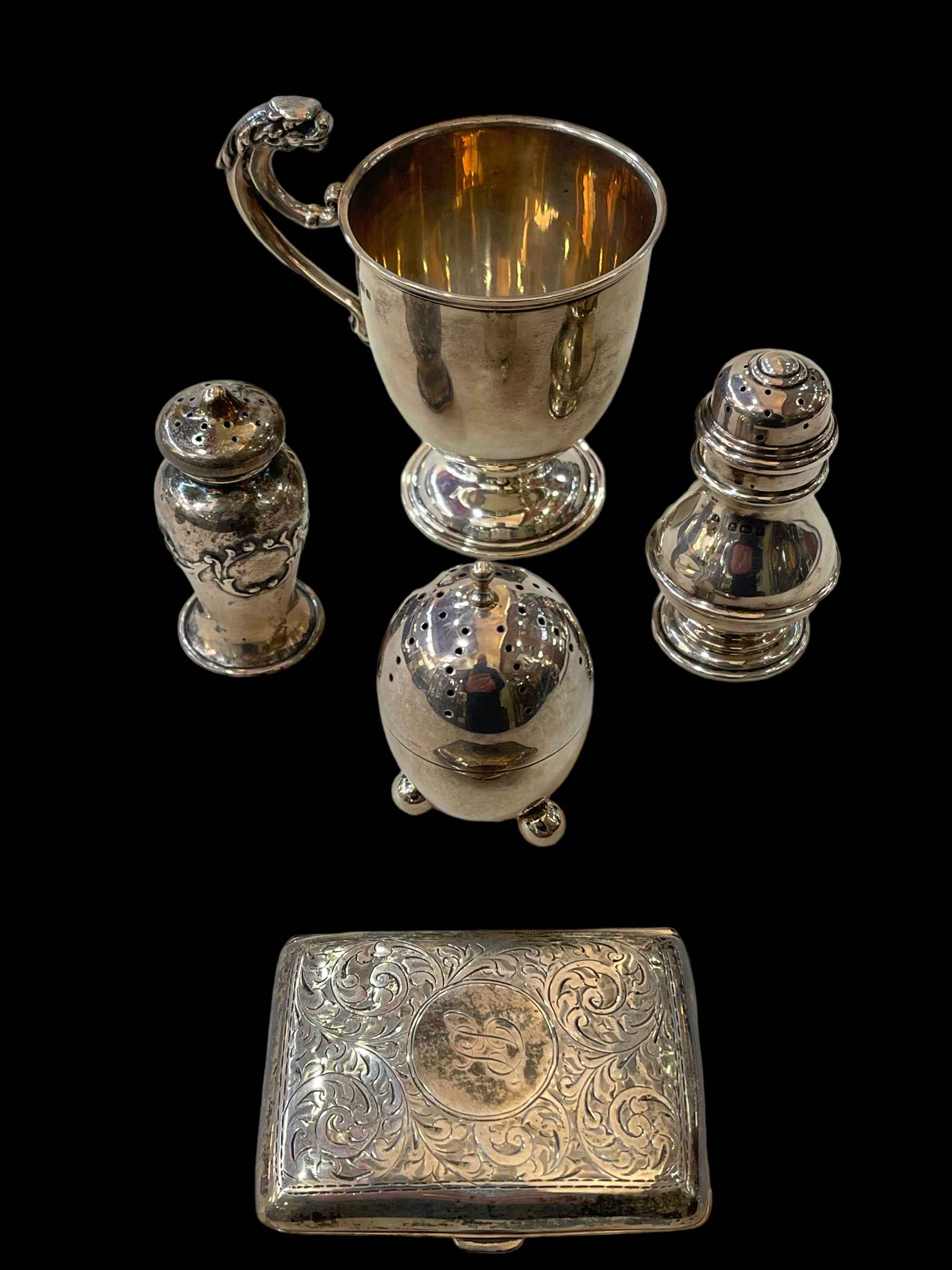 Silver pieces comprising: christening mug, cigarette case, and three pepperettes (5).