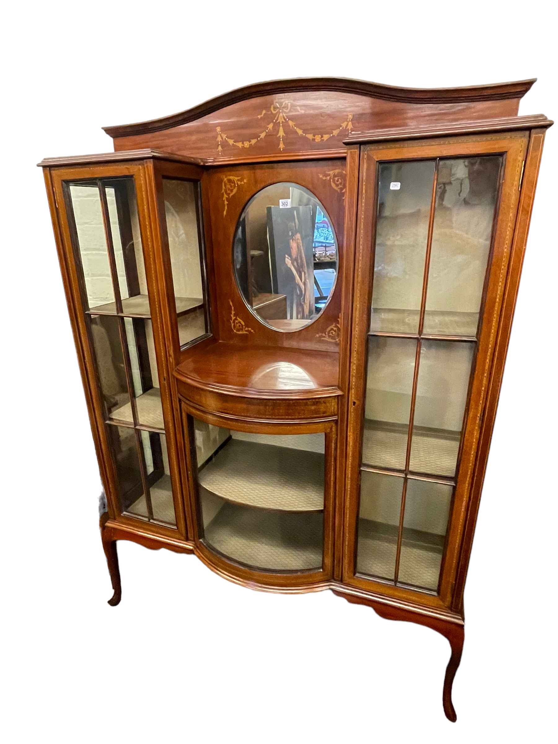 Edwardian inlaid mahogany cabinet having central oval bevelled mirror above a bow glazed door