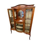 Edwardian inlaid mahogany cabinet having central oval bevelled mirror above a bow glazed door