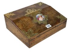 Ornate Victorian walnut and brass mounted writing slope with porcelain cherub insert, 30cm by 11cm.