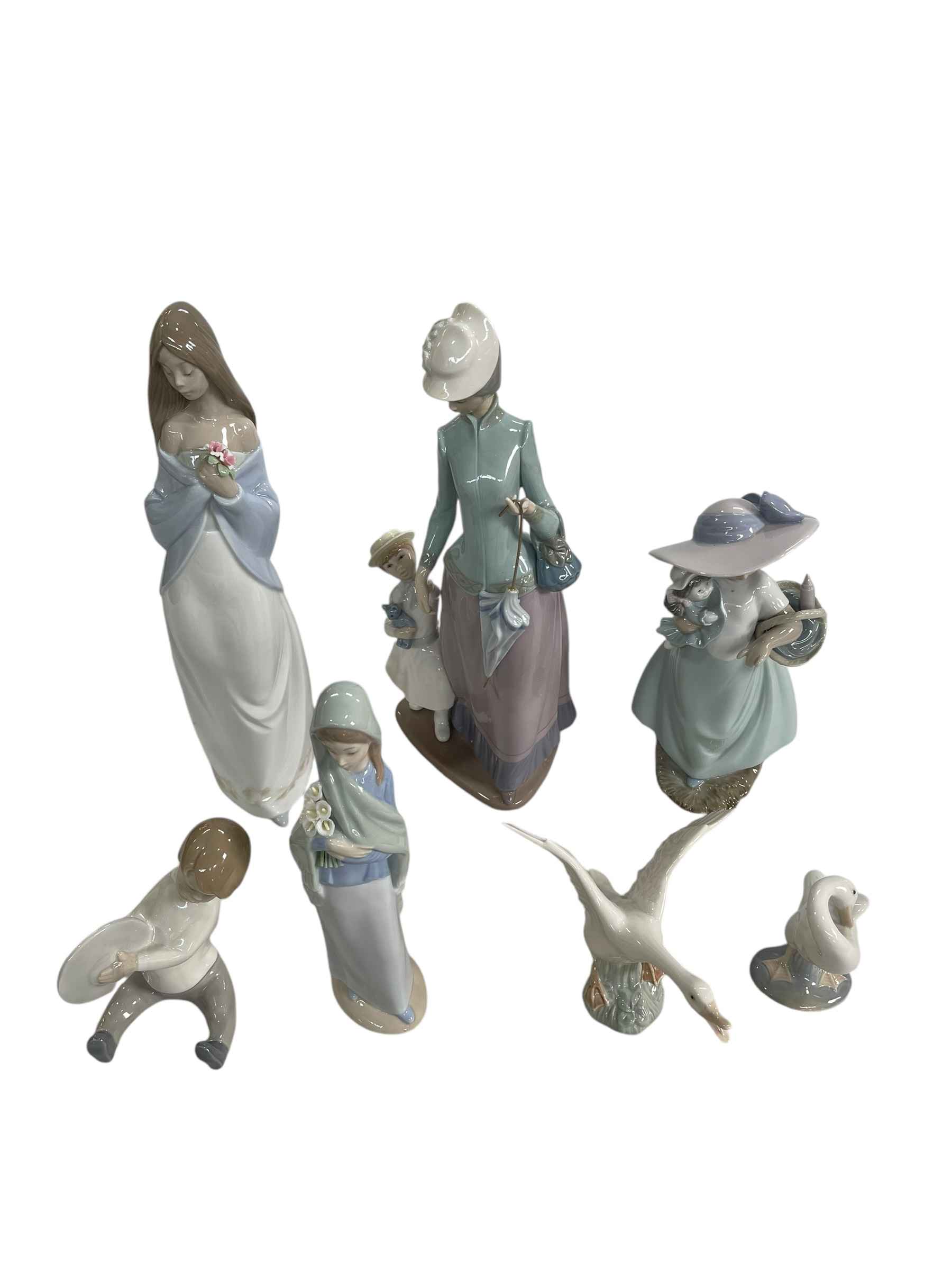 Three Lladro figures and two geese and two Nao figures.