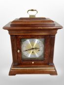 A reproduction Howard Miller eight day bracket clock with brass and silvered dial,