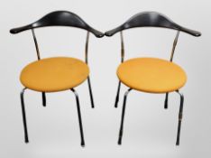A pair of late 20th century Danish chrome framed elbow chairs with orange fabric seats