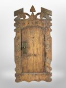 An early 20th century carved pine wall cabinet,