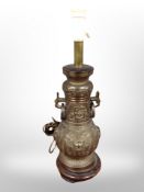 A heavy cast brass oriental style lamp base on wooden stand,