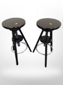 A pair of contemporary ebonised adjustable rise and fall bar stools