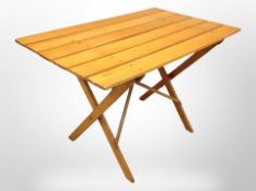 A pine folding table on X-framed support,