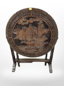An Eastern carved folding circular table,