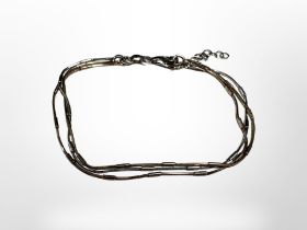 A three-tone silver three strand bracelet