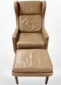 A late 20th century brown leather wingback armchair with matching footstool