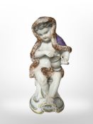 A 19th century Continental porcelain figure of a Putto representing winter,
