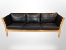 A late 20th century Danish beech framed black stitched leather three seater settee,