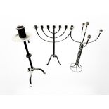 A wrought iron menorah and two similar candle stands,